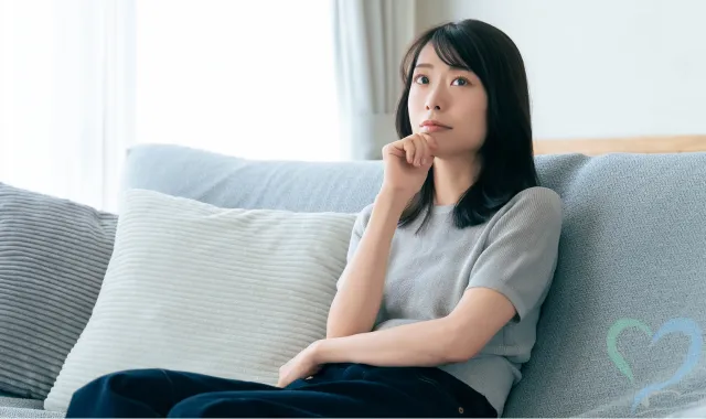 ソファに座って相談先に迷う女性